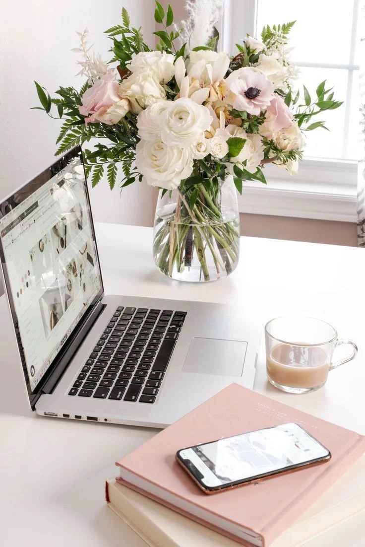 Cozy home office with laptop, coffee and pink peonies